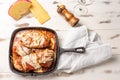 Parmegiana Steak also known as Filet Parmegiana in a black iron pan on a wooden white background, cheese and tomato sauce. Soft Royalty Free Stock Photo