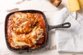 Parmegiana Steak also known as Filet Parmegiana in a black iron pan on a wooden white background, cheese and tomato sauce. Soft Royalty Free Stock Photo