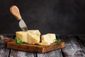 Parmesan cheese on a cutting board with basil leaves, rustic wooden table. Selective frus Royalty Free Stock Photo