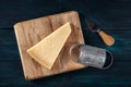 Parmesan cheese with a knife and a grater, overhead flat lay shot Royalty Free Stock Photo