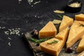 Parmesan cheese on a wooden board, Hard cheese, olives, rosemary and metal grater. place for text, top view