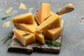 Parmesan cheese on a wooden board, Hard cheese, olives, rosemary on a light background