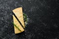 Parmesan. Pieces of Parmesan cheese on black stone background. Top view.