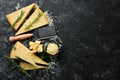 Parmesan. Pieces of Parmesan cheese on black stone background. Top view.