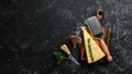 Parmesan. Pieces of Parmesan cheese on black stone background. Top view.