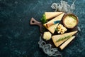 Parmesan. Pieces of Parmesan cheese on black stone background. Top view.