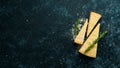 Parmesan. Pieces of Parmesan cheese on black stone background. Top view.