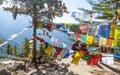 Paro, Bhutan - February 2016: buddhist monk in traditional red clothes and multicolor prayer Tibetan Buddhist flags Lung Ta in Royalty Free Stock Photo