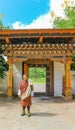 Paro, Bhutan - September 10, 2016: Bhutanese man wearing traditional dress standing in front of the door in Kichu Lhakhang temple.