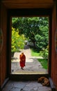 Paro, Bhutan - September 10, 2016: Bhutanese monk walking through the door in Kichu Lhakhang temple. Royalty Free Stock Photo