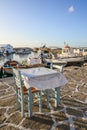 Table and chairs in seaside restaurant in beautiful Naoussa harbor on Paros Island. Cyclades,