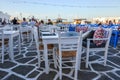 Table and chairs in seaside restaurant in beautiful Naoussa harbor on Paros Island. Cyclades,