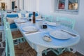 Tables and chairs in seaside restaurant in beautiful Naoussa harbor on Paros Island. Cyclades