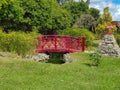 In the Park of Brazil, a red bridge over a small lake stands out amidst the green Royalty Free Stock Photo