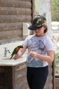 Parrot Lori - Loriinae - sits on the arm of the girl and eats an apple at the Gan Guru Zoo in Kibbutz Nir David in Israel