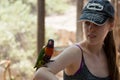 Parrot sits on the hand of a young woman at the Australian Zoo Gan Guru in Kibbutz Nir David, in Israel