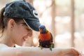 Parrot sits on the hand of a young woman at the Australian Zoo Gan Guru in Kibbutz Nir David, in Israel