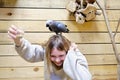 The parrot is sitting on the girl\'s head. The girl is very happy from playing with a parrot Royalty Free Stock Photo