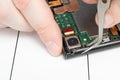 Parsing a mobile phone. The wizard detaches smartphone parts using special tools