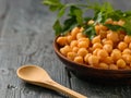 Parsley branch on a bowl with boiled chickpeas on a black table