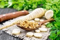 Parsley root dried in spoon on dark board