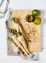 Parsley root with a measuring tape and tomatoes on cutting board on a white background of the old wooden boards vintage top view Royalty Free Stock Photo