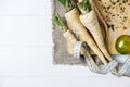 Parsley root with a measuring tape and tomatoes on cutting board on a white background of the old wooden boards vintage top view Royalty Free Stock Photo