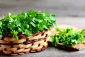 Parsley sprigs in a brown wicker basket and wooden board. Garden parsley herbs. Organic effective source of anti-oxidant nutrients Royalty Free Stock Photo