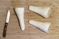 Parsnips and knife on wooden chopping board close up detail preperation for cooking vegetable view above