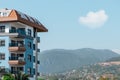 Part of an apartment building against the backdrop of a mountain and blue sky Royalty Free Stock Photo