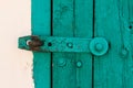 The Part of Aquamarine Old Vintage Door with Crack Paint and Big Steel Bolt on the White Wool, Texture, Background Royalty Free Stock Photo