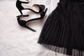 Part of a black pleated skirt and black shoes. Fashion concept. Close-up