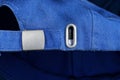 part of a blue cap made of fabric with a metal gray fastener Royalty Free Stock Photo