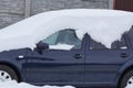 Blue passenger car under a snowdrift of white snow on the street Royalty Free Stock Photo