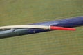 Part of a blue plastic fishing rod with a long red white float on a fishing line