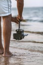 Part of the body of a young man with a camera attached to a steadicam, a videographer shoots video walking barefoot along the