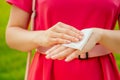 Part of the body of a young woman in a pink park . girl using wet wipes the sweat at hands