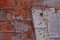 Part of a brick wall with peeling white, gray and red paint Royalty Free Stock Photo