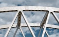 Part bridge supporting structure close up against a cloudy sky