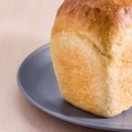 Part of a bright loaf of white bread on a blue plate