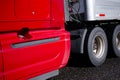 Part of bright red semi truck with aluminum trailer with wheels Royalty Free Stock Photo