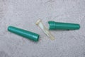 part of a brown broken pipette and an open green plastic case parts