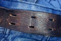 Part of a brown leather belt on a blue cotton fabric Royalty Free Stock Photo