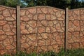Part of a brown long stone wall of a fence