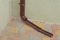 Part of a brown plastic drain pipe on a gray wall of a building Royalty Free Stock Photo