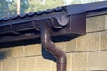 Part of brown plastic drain pipe under the roof of a house Royalty Free Stock Photo