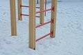 Part of brown red stairs in white snow on a playground