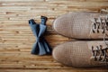 Part brown stylish wedding shoes, bow tie lying on a wooden floor. Accessories groom