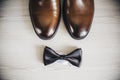 Part brown stylish wedding shoes, butterfly lying on a light table. White background. Accessories groom