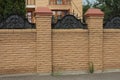 Part of a brown wall of a brick fence